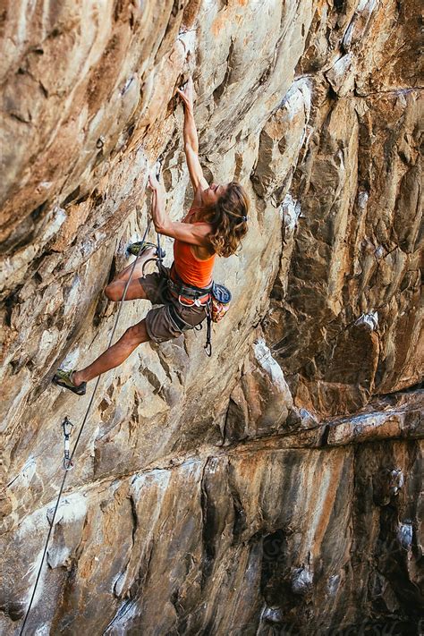 Female Rock Climber Climbing A Cliff On A Mountain By Stocksy