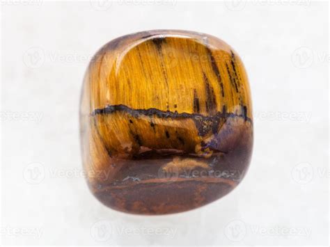 Tumbled Tiger Eye Gem Stone On White Marble 12999399 Stock Photo At