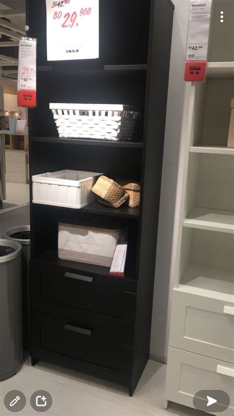 a black bookcase with baskets and other items on it in a store display area