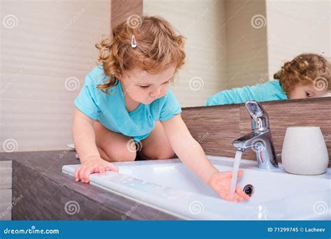 Petite Fille Se Lavant Les Mains Dans La Salle De Bains Image Stock