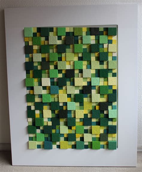 A Green And Yellow Piece Of Art Hanging On A Wall Next To A White Frame