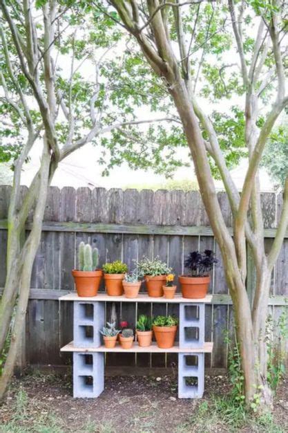 Several Potted Plants Are Sitting On Top Of A Wooden Shelf In Front Of