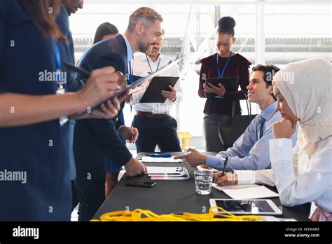 Business People Checking In At Conference Registration Table Stock