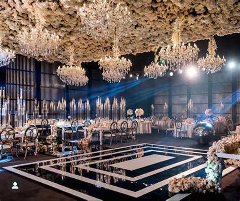 An Elaborately Decorated Banquet Hall With Chandeliers And Tables Set