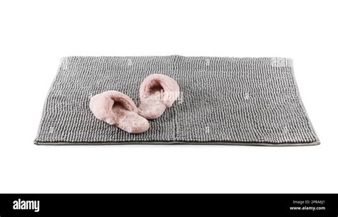 New grey bath mat with fluffy slippers isolated on white Stock Photo - Alamy