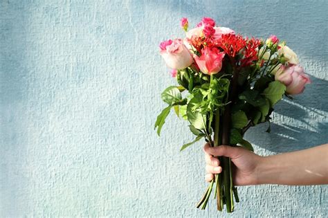 Premium Photo Woman Hand Holding Bouquet Of Fresh Flowers On Light