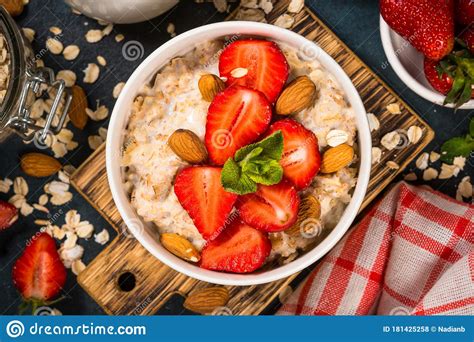 Oatmeal Porridge With Fresh Strawberry And Nuts On Dark Background