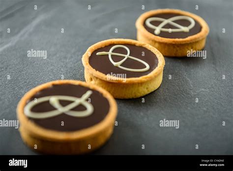 Three Round Chocolate And Caramel Pastry Tarts In A Diagonal Row Shot