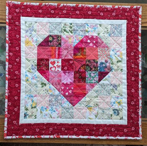 A Quilted Heart Is Hanging On The Wall