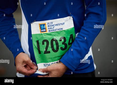 Marathon runner fixing number bib pins Aldi sponsored event man male ...