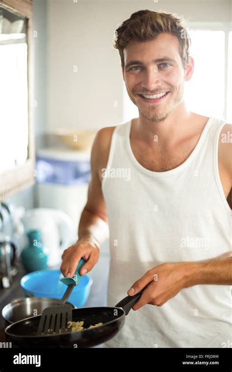 Portrait Of Smiling Man Cooking Food In Kitchen Stock Photo Alamy