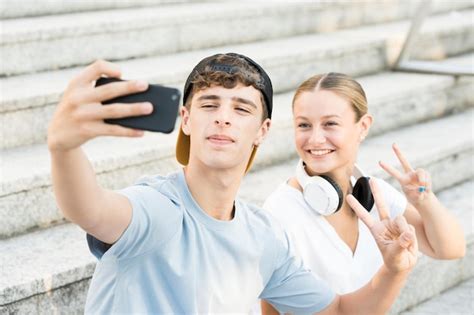 Dos amigos haciéndose un selfie en las escaleras Foto Premium