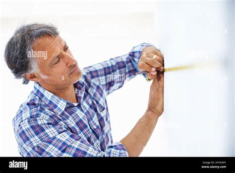 Mature Architect Taking Wall Measurement Closeup Of Mature Architect