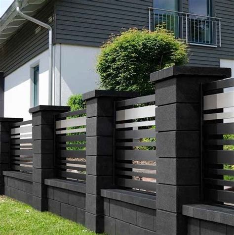 A Black And White Fence In Front Of A House With Grass On The Ground