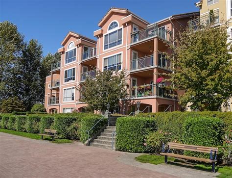 Edificio De Apartamentos En Un D A Soleado Con Banco Y Camino