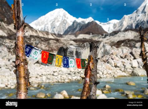 Prayer Flags With Glacial River And Snow Capped Mountains In Distance