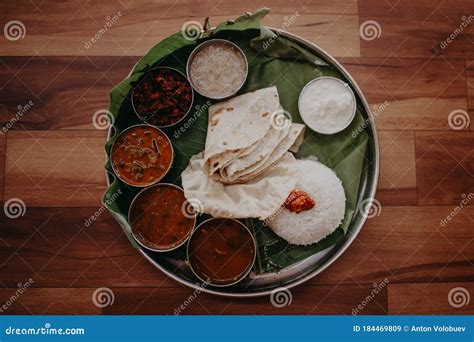 Traditional Indian Steel Plate Thali On Banana Leaves With Various