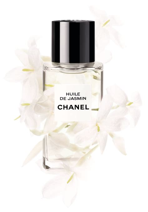 A Bottle Of Perfume With White Flowers Around It