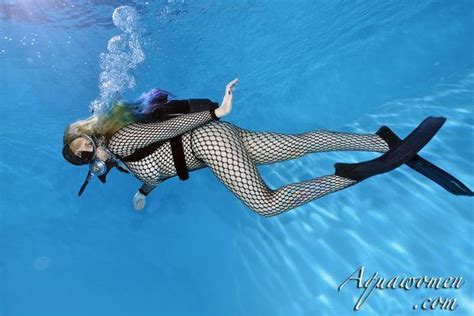 A Woman In Fishnets And Boots Is Floating Under Water With Her Arms