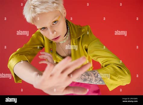 Overhead View Of Blonde Albino Woman With Tattoo Looking At Camera