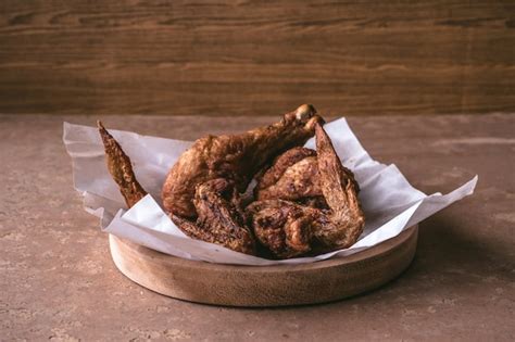 Piernas Y Alas De Pollo Frito En Plato De Madera En La Tabla Foto