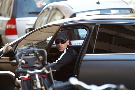 A Man Sitting In The Driver S Seat Of A Car Next To A Motorcycle