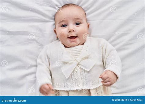 Adorable Baby Smiling Confident Lying On Bed At Bedroom Stock Photo