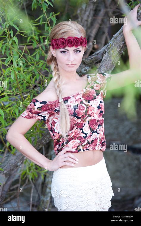 Une jeune fille superbe blonde regardant la caméra tout en portant une couronne de fleurs rouge