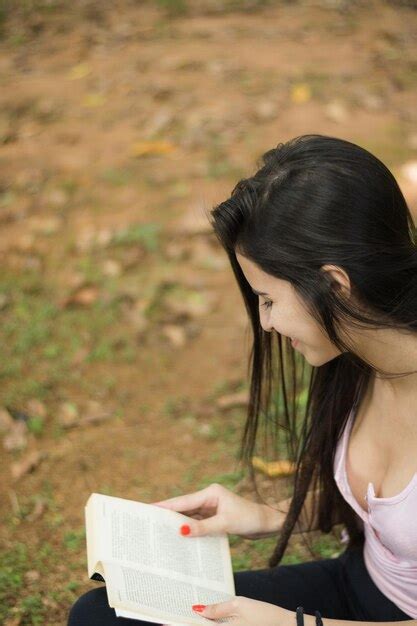 Premium Photo Smiling Woman Reading Book While Sitting Outdoors