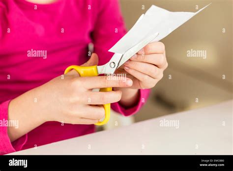 Girl Cutting Piece Of Paper Stock Photo Alamy
