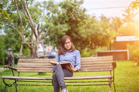 Livre De Relev De Femme Sur Le Banc De Stationnement Photo Stock