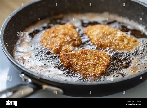 Breaded Schnitzels Are Frying In A Sizzling Pan Making The Traditional