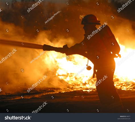 A Firefighter Hoses Down A Blaze Stock Photo 49671 Shutterstock