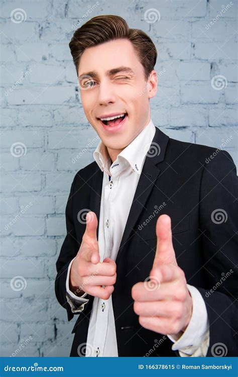 Portrait Of Handsome Young Businessman Winking And Pointing On Camera