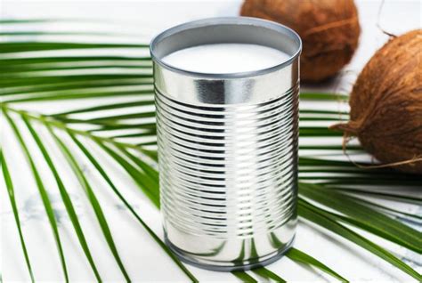 A Can Of Coconut Milk Next To Two Whole Coconuts