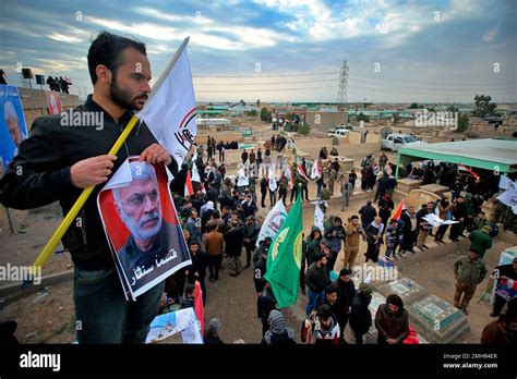 A Mourner Holds Posters Of Abu Mahdi Al Muhandis Deputy Commander Of