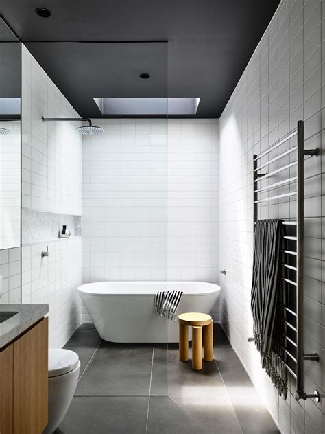 A White Bath Tub Sitting Next To A Toilet In A Bathroom Under A Skylight