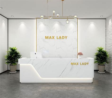 a white marble reception desk with gold lettering on the front and side ...