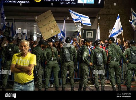 Israeli Border Police Officers Line Up In Front Of Protesters Waving