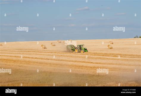 Tractor Collecting Straw Stock Photo Alamy