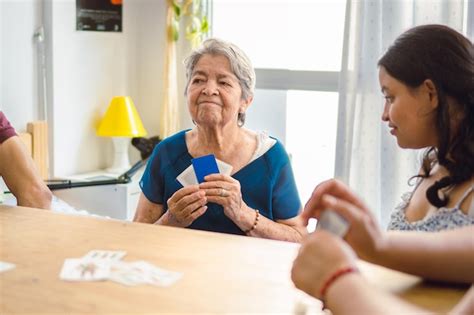 Abuela Latina Analizando A Su Oponente En Un Juego De Cartas En Su Sala