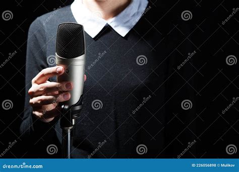 Female Singer On The Stage Holding A Microphone On A Dark Background