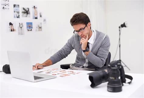 Editing the Shoot. a Young Photographer Sitting at His Desk Editing ... 