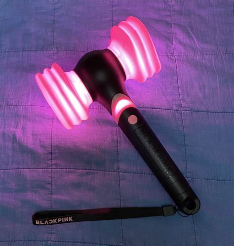 A Pink And Black Blow Dryer Sitting On Top Of A Purple Blanket