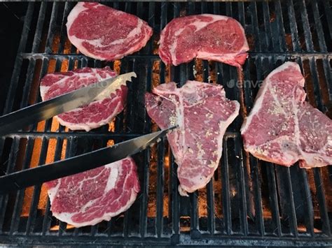 Cooking delicious steaks on the bbq grill for dinner. Stock Photo by ...