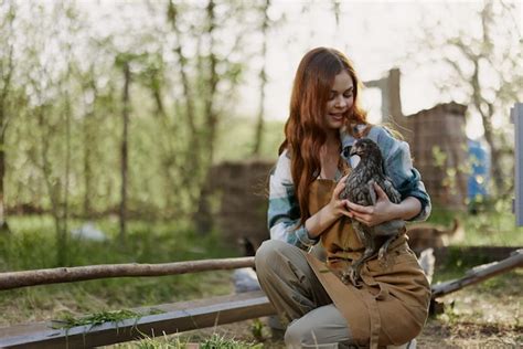 Une femme examine un poulet dans ses mains et se frotte le front à