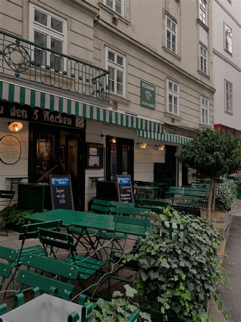 An Outdoor Cafe With Green Tables And Chairs On The Sidewalk In Front