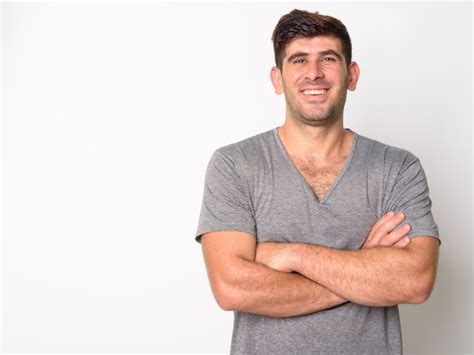 Retrato De Feliz Joven Persa Sonriendo Con Los Brazos Cruzados Foto