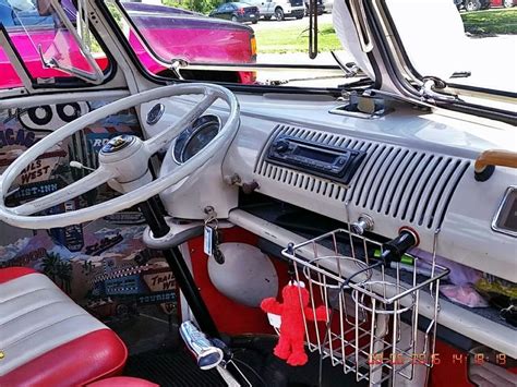 The Interior Of An Old School Bus With Red Seats And Chrome Steering