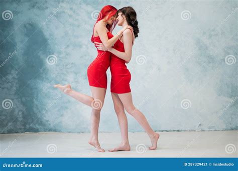 Full Length Portrait Of Two Tenderly Embracing Women Dressed In